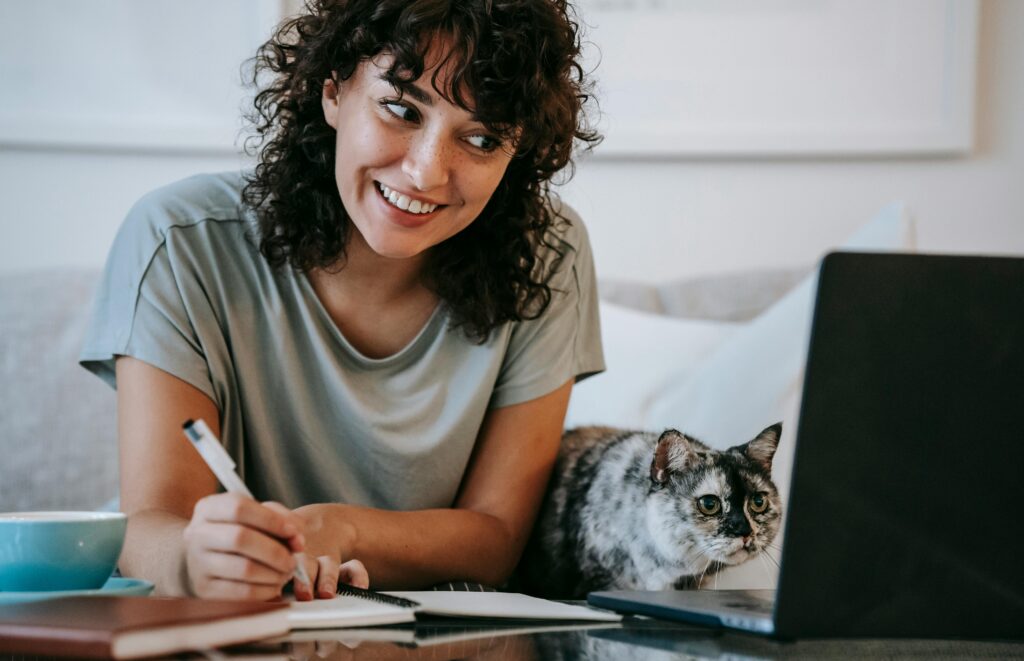 A freelancer working on one of our new projects that support our mission, with her pet cat beside her. 